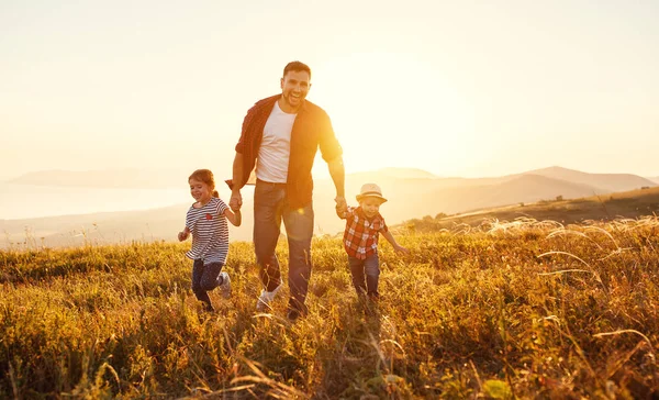 Gelukkig gezin vader en kinderen in de natuur op sunse — Stockfoto