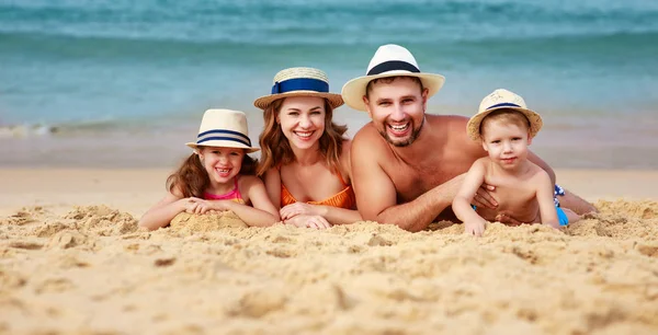 Feliz familia padre, madre e hijos en la playa en sí —  Fotos de Stock