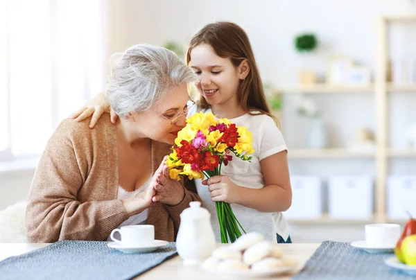 Happy mother's day! wnuczka daje kwiaty i pogratulować — Zdjęcie stockowe