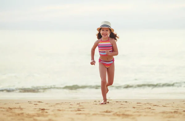 Щаслива дівчина з купальником і капелюхом на пляжі на сонці — стокове фото