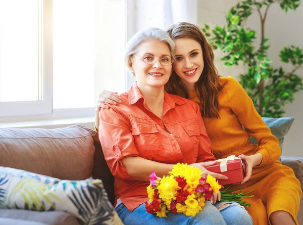 Happy mother's day! adult daughter gives flowers and congratulat — Stock Photo, Image