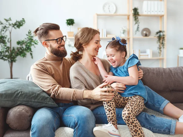 Mutlu aile anne baba ve çocuk kız evde gülüyor — Stok fotoğraf