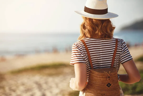 Happy tourist girl with backpack and hat on sea — Stock Photo, Image