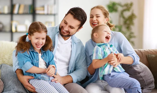 Família feliz mãe pai e filhos em casa no sofá — Fotografia de Stock