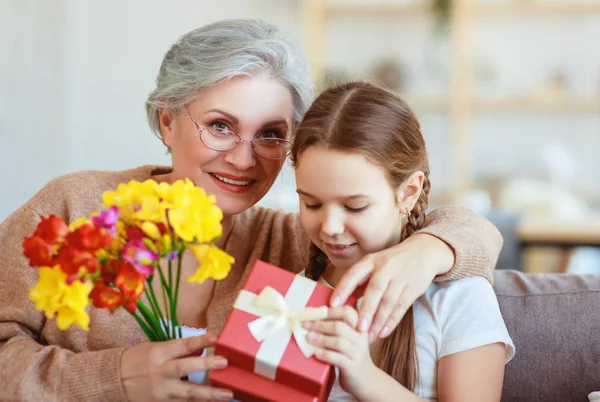 Feliz dia da mãe! neta dá flores e parabeniza — Fotografia de Stock