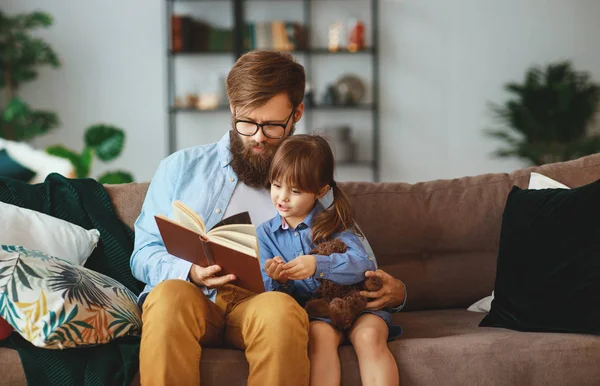Щаслива сім'я. батько читає книгу дитині дочці вдома — стокове фото