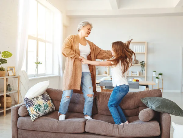 Feliz familia abuela y nieta bailando y reír en casa —  Fotos de Stock