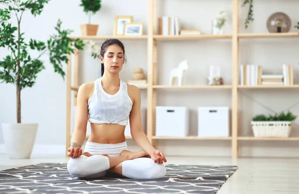 Mujer haciendo yoga, meditando en posición de Loto en casa — Foto de Stock