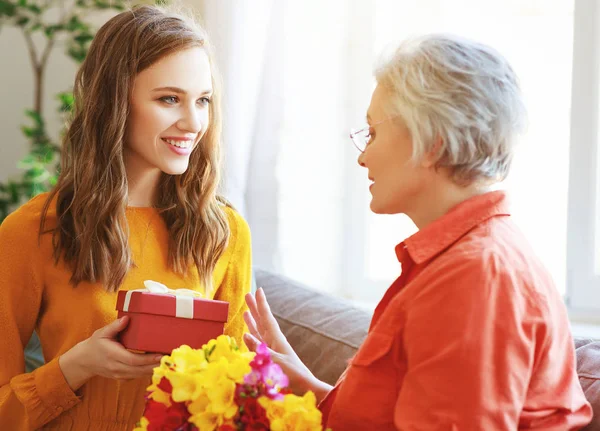 Happy mother's day! adult daughter gives flowers and congratulat — Stock Photo, Image