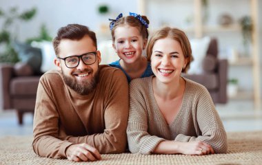 mutlu aile anne baba ve çocuk kız evde gülüyor