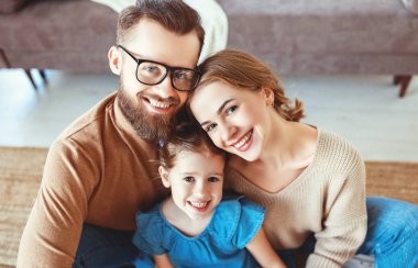 mutlu aile anne baba ve çocuk kız evde gülüyor