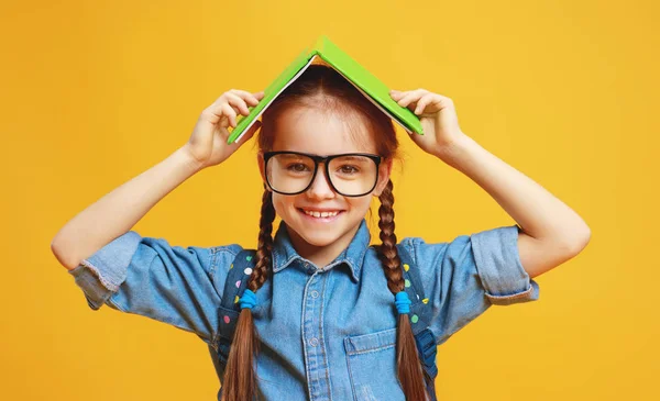 Lustige Kind Schulmädchen auf gelbem Hintergrund — Stockfoto