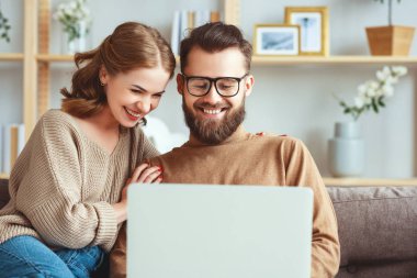 mutlu çift evde dizüstü bilgisayar ile 