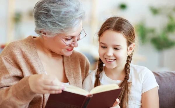 Família feliz avó lendo a neta livro em casa — Fotografia de Stock