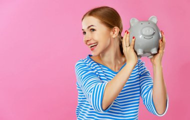  pembe arka plan üzerinde domuzcuk para banka ile mutlu kadın. Finansal