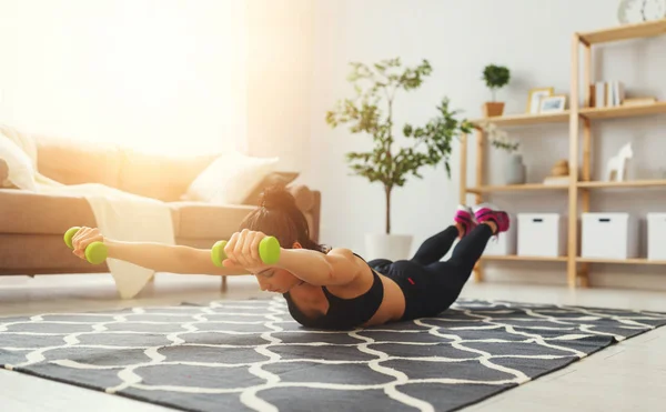 Mujer joven haciendo ejercicio y deportes en casa —  Fotos de Stock