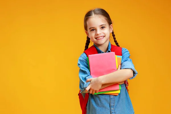 Criança engraçada menina da escola no fundo amarelo — Fotografia de Stock