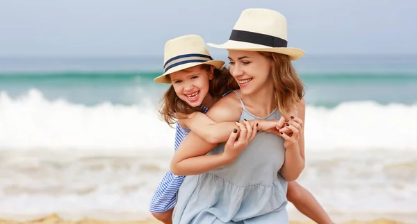 Familia feliz en la playa. madre e hija hija abrazo en el mar —  Fotos de Stock