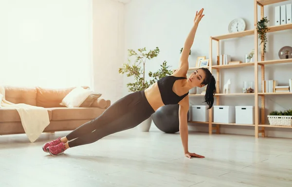 Mujer joven haciendo ejercicio y deportes en casa — Foto de Stock