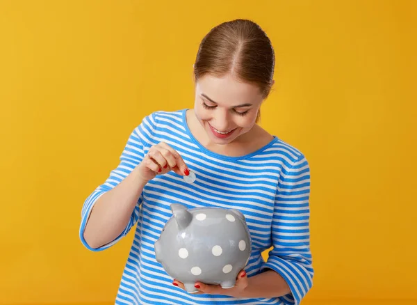 happy woman with piggy money bank on pink background. financial