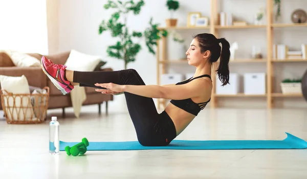 Jovem mulher fazendo fitness e esportes em casa — Fotografia de Stock