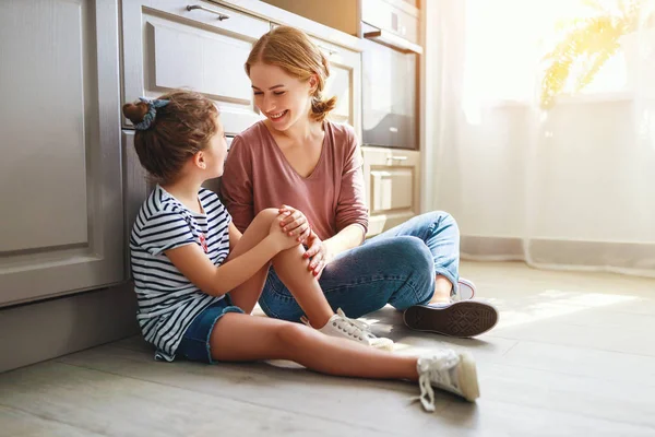 Dla rodzin z dziećmi córka matki i dziecka, przytulanie w kuchni na podłodze — Zdjęcie stockowe
