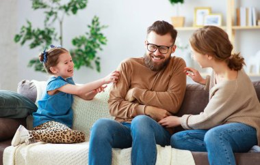 mutlu aile anne baba ve çocuk kız evde gülüyor