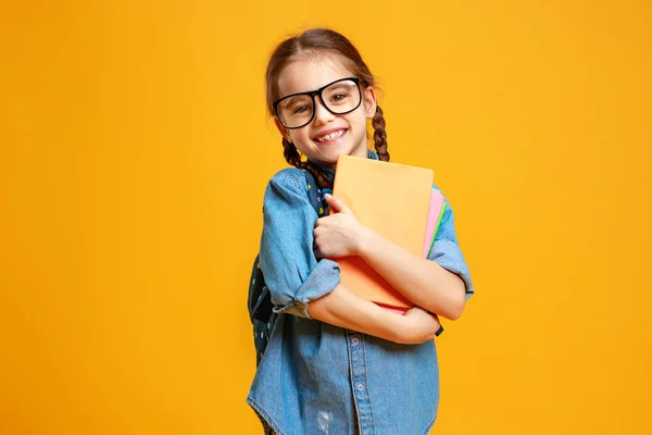 Criança engraçada menina da escola no fundo amarelo — Fotografia de Stock