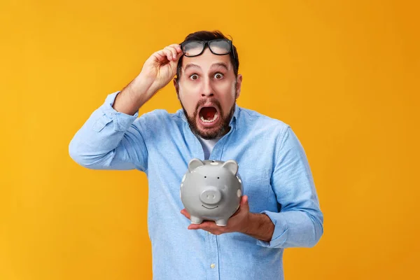 Conceito de Finanças e negócios. homem com porquinho Banco em yello — Fotografia de Stock