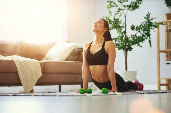 Jovem mulher fazendo fitness e esportes em casa — Fotografia de Stock