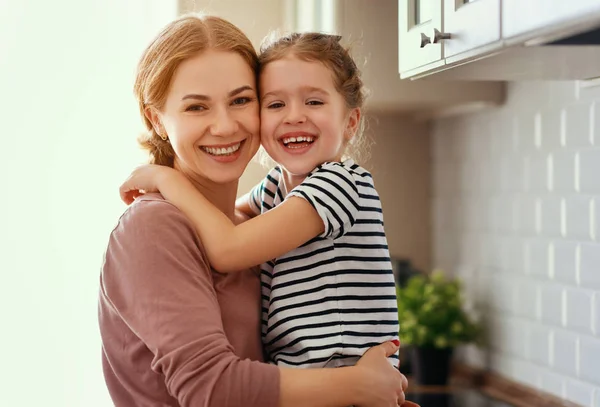 Family mother and child daughter hugging in kitchen — Stock Photo, Image