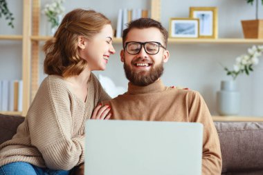 mutlu çift evde dizüstü bilgisayar ile 