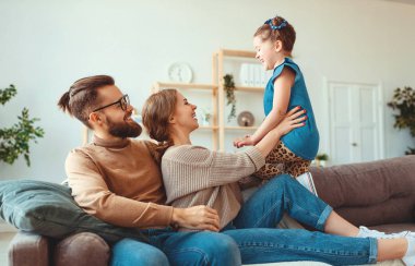 mutlu aile anne baba ve çocuk kız evde gülüyor