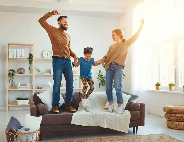 Mutlu aile, anne, baba ve kız evde dans ediyor. 