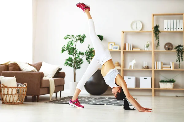 Mujer joven haciendo ejercicio y deportes en casa —  Fotos de Stock