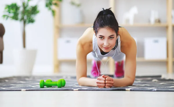 Mujer joven haciendo ejercicio y deportes en casa —  Fotos de Stock