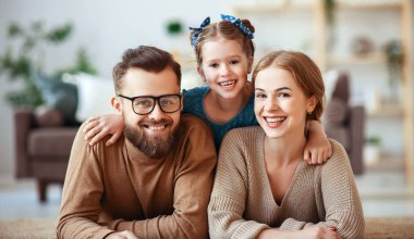 mutlu aile anne baba ve çocuk kız evde gülüyor