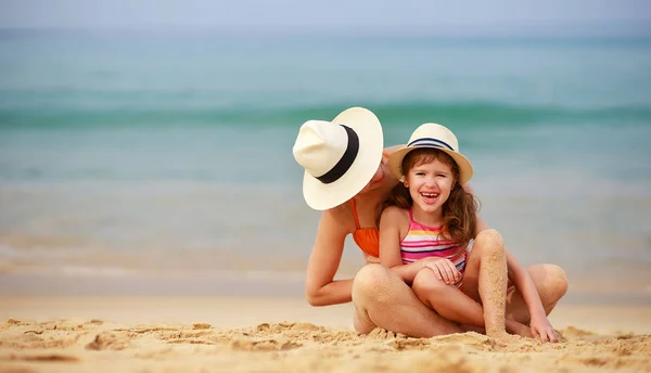 Lycklig familj på stranden. mor och barn dotter kram på se — Stockfoto
