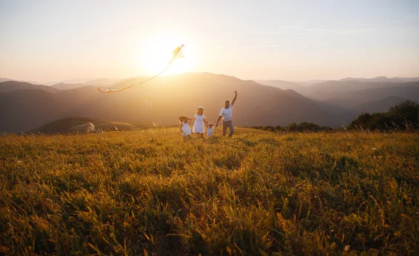 Gelukkige familie vader, moeder en kinderen lanceren Kite op de natuur — Stockfoto