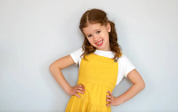 Ευτυχισμένο χαρούμενο παιδί κορίτσι σε κίτρινο — Φωτογραφία Αρχείου