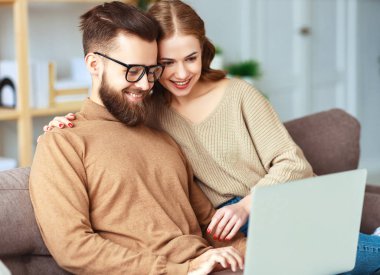 mutlu çift evde dizüstü bilgisayar ile  