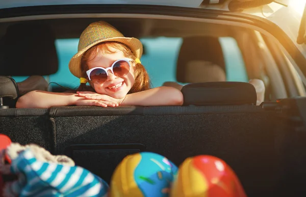 Happy child girl in car going on a summer vacation tri — Stock Photo, Image