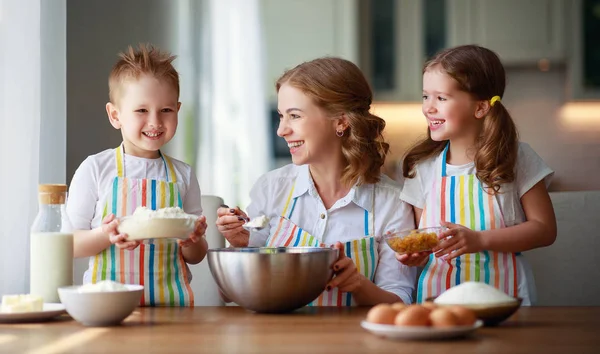 Família feliz na cozinha. mãe e filhos preparando massa, ba — Fotografia de Stock