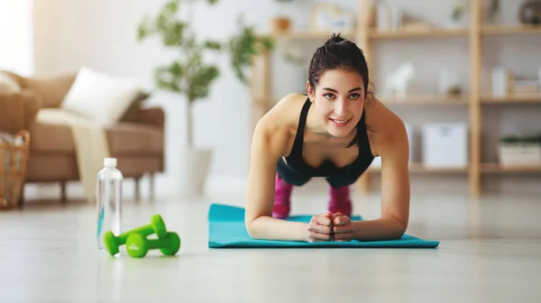 Jovem mulher fazendo fitness e esportes em casa — Fotografia de Stock