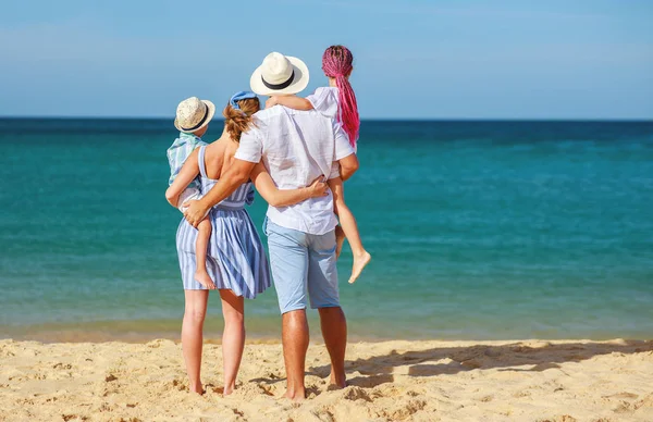 Счастливые отец, мать и дети снова на пляже в море — стоковое фото