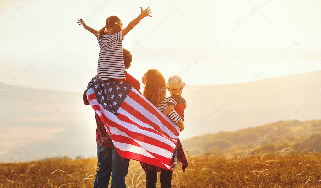 happy family with flag of america USA at sunset outdoor