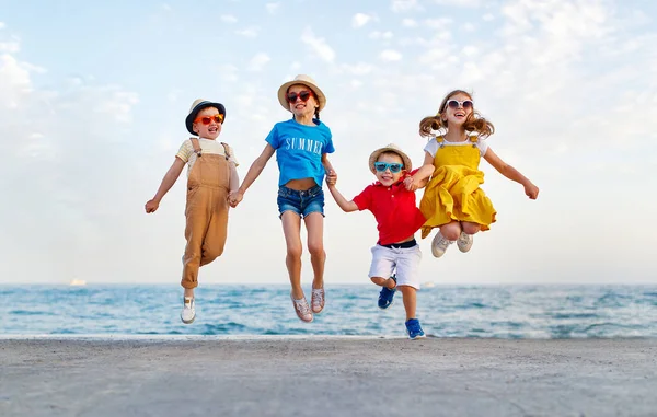 Ομάδα των ευτυχισμένα παιδιά άλμα από τη θάλασσα το καλοκαίρι — Φωτογραφία Αρχείου