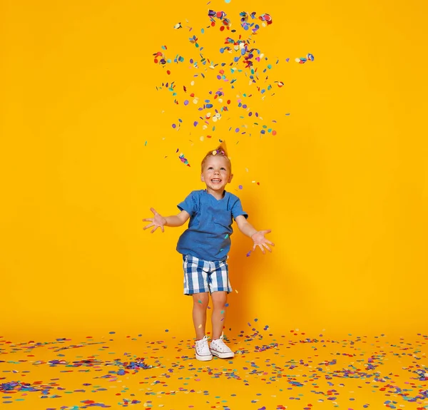 黄色のバックグローンに紙吹雪を持つ幸せな誕生日の子供の男の子 — ストック写真