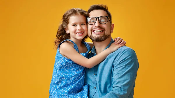 Happy father's day! cute dad and daughter hugging on yellow back — Stock Photo, Image