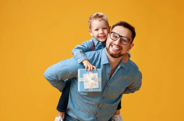 Szczęśliwy dzień ojca! cute tata i syn przytulanie na żółtym oświetlenie tła — Zdjęcie stockowe